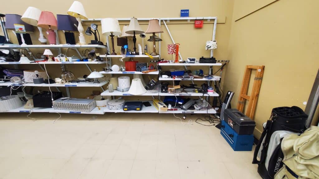 Shelves in a reuse store showing secondhand bedside lamps